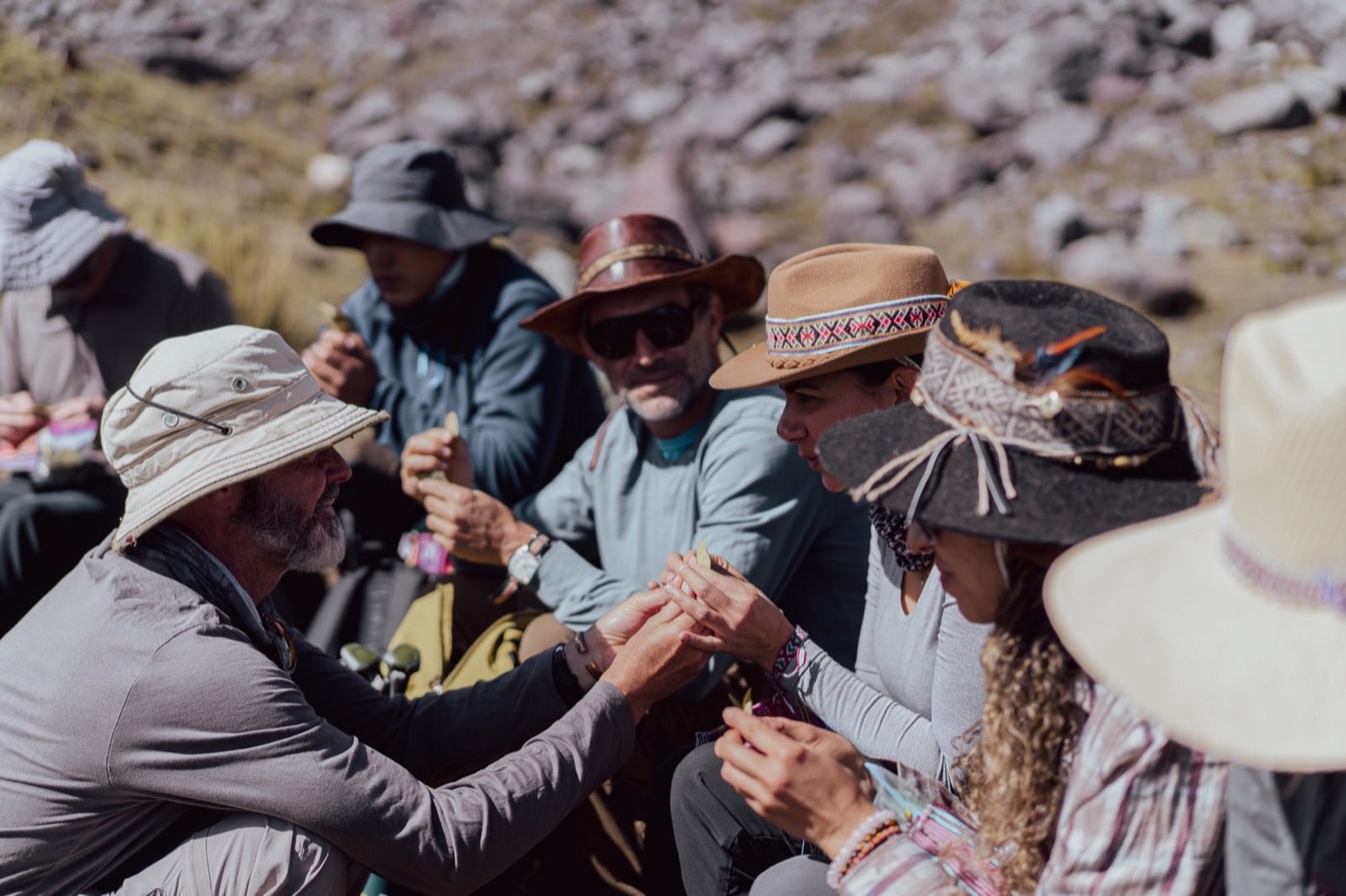 Participantes comparten hojas de coca durante una pausa en la montaña.