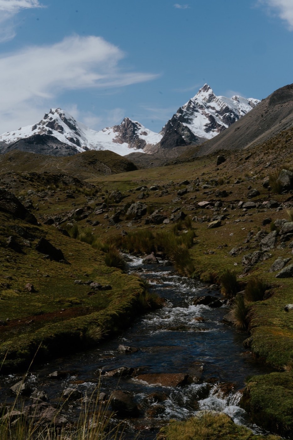 Arroyo glaciar recorre el valle bajo las cumbres nevadas del Ausangate.