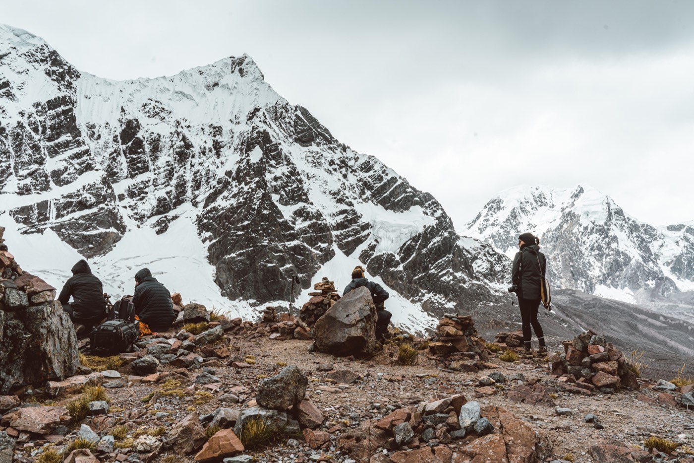 Participantes hacen una pausa contemplativa entre apachetas y cumbres nevadas.