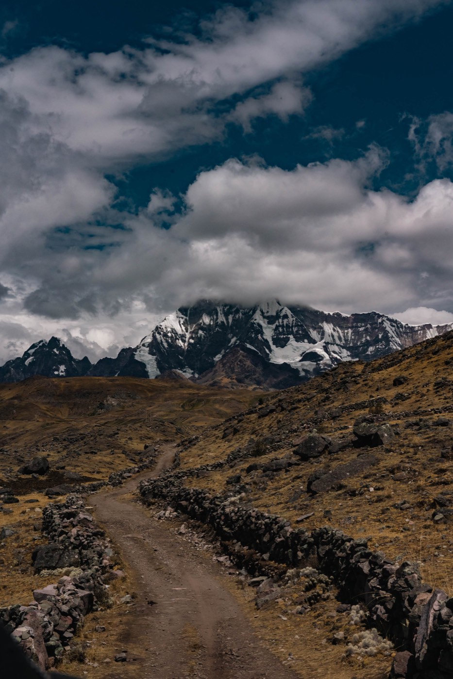 Sendero de piedra que conduce hacia las cumbres nevadas del Ausangate.