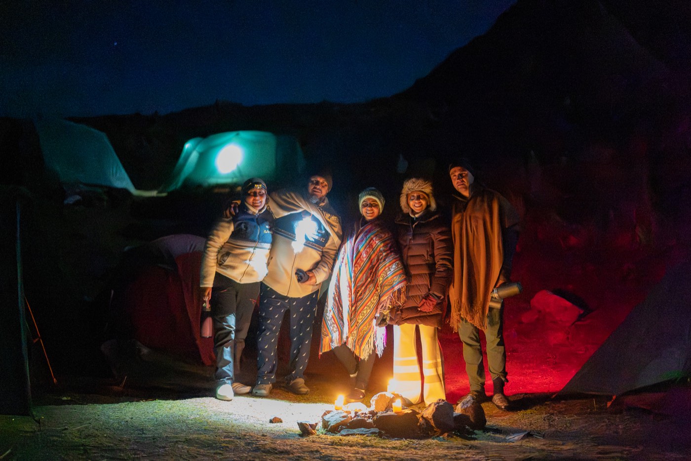 Participantes reunidos junto a las tiendas durante la noche de campamento.